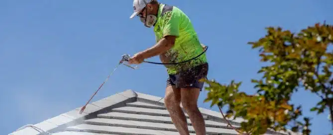 Permacoat" roof coating application. Contractor spraying white protective coating on roof tiles.