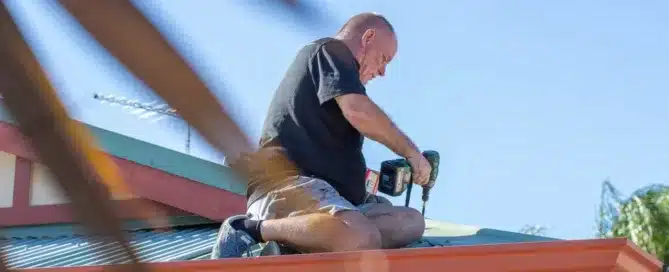 Man repairing roof with power drill. Shows "Permacoat" roofing expertise.
