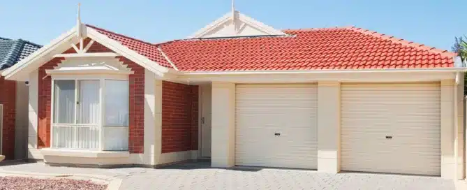 Red tiled roof on modern brick home with double garage. "Innovative Roofing Solutions.