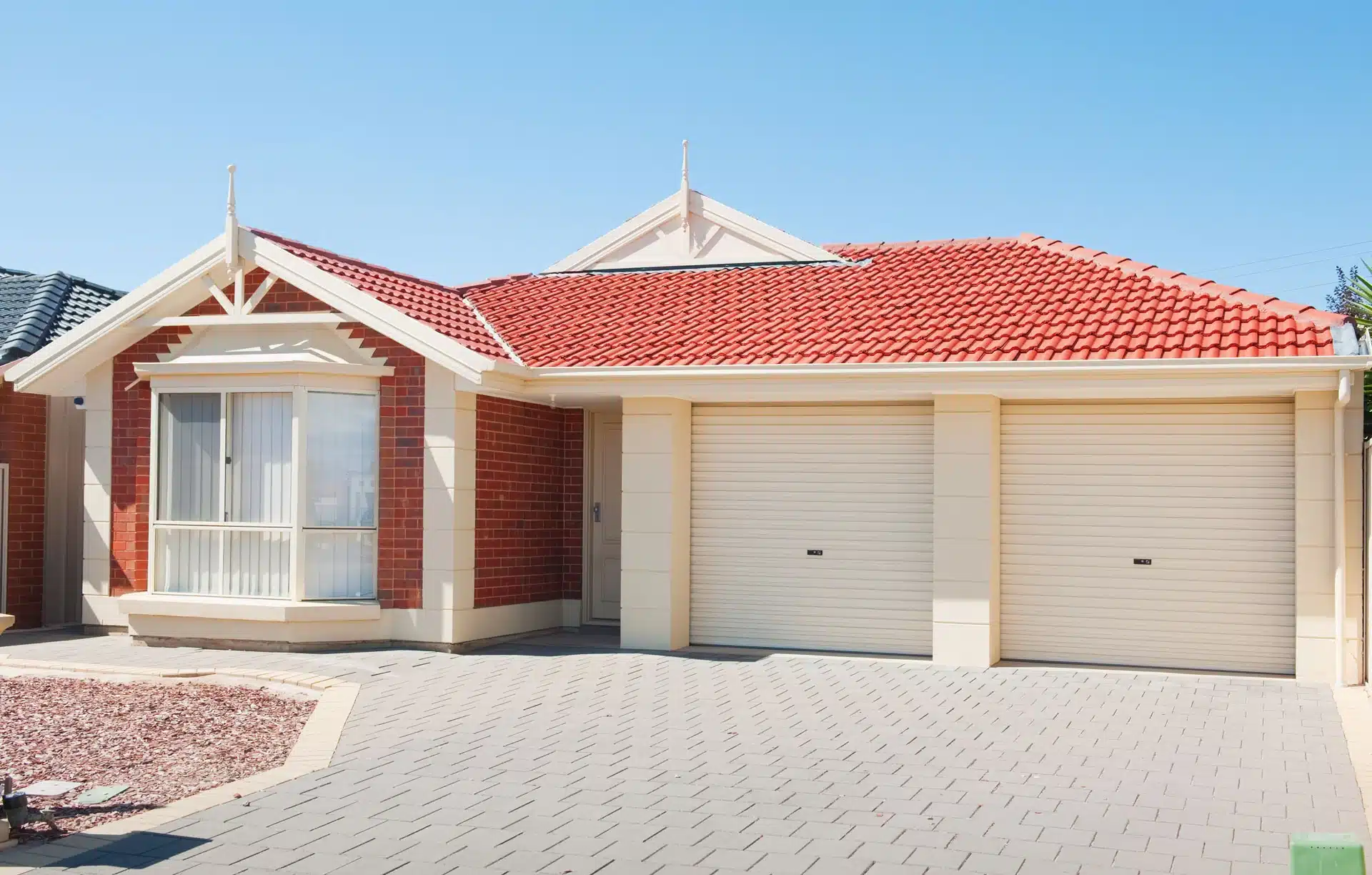 Red tiled roof on modern brick home with double garage. "Innovative Roofing Solutions.