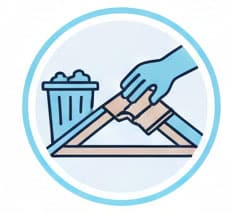 Hand placing trash into a garbage bin on an angled surface representing waste management and recycling.